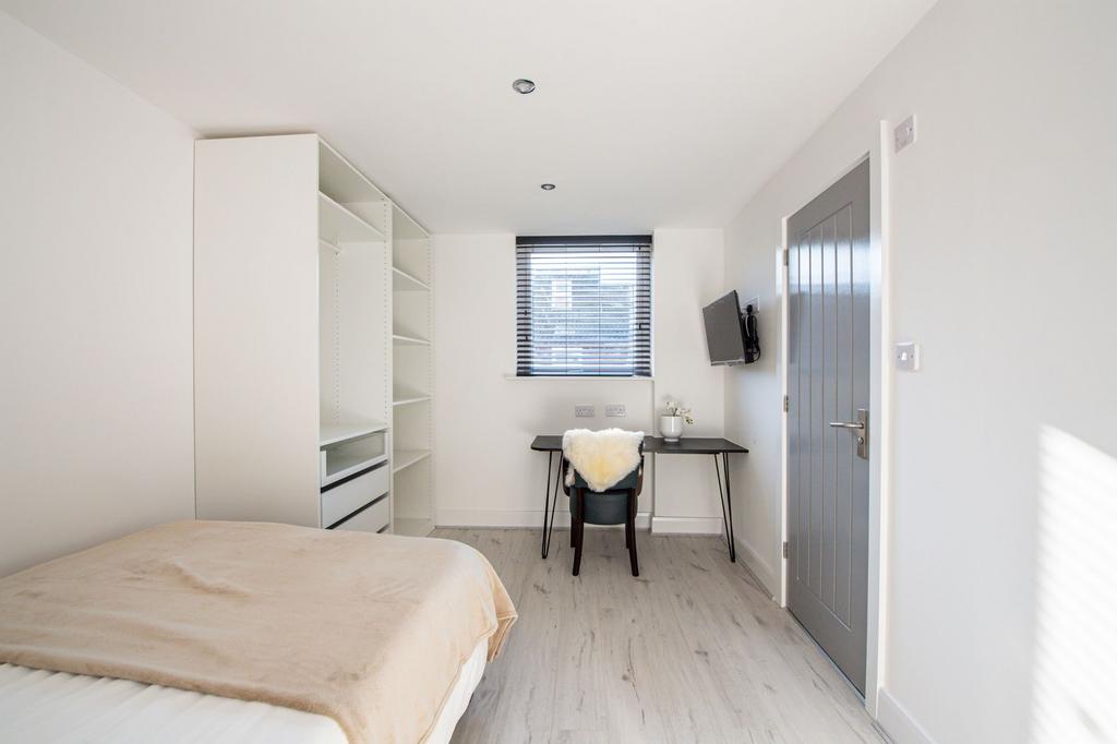 Bright and tidy bedroom with a comfortable bed,...
