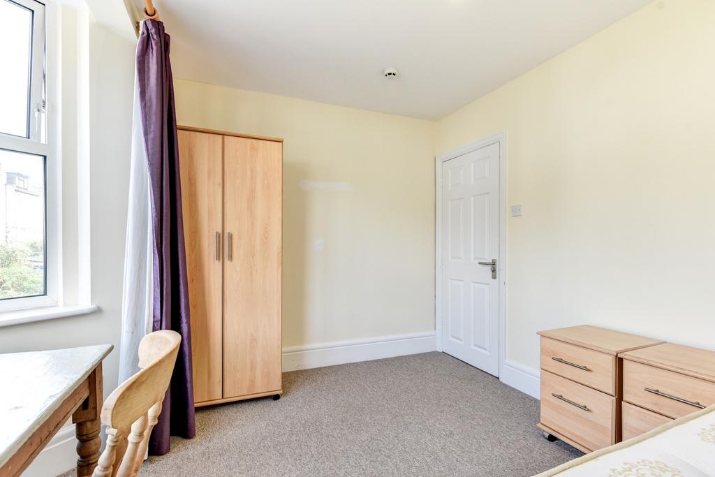 A bright and airy bedroom featuring a wardrobe ...