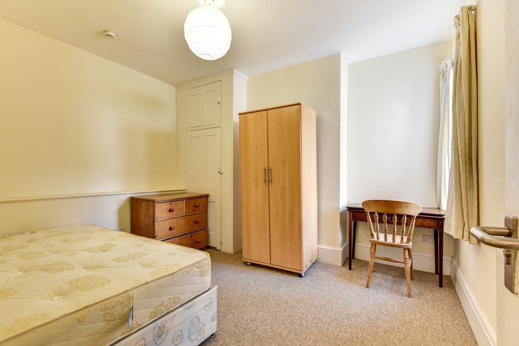 A spacious double bedroom with natural light co...