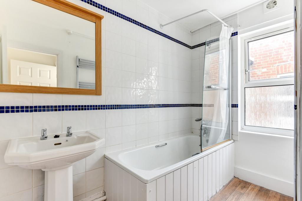 Bright and clean bathroom featuring a bathtub, ...