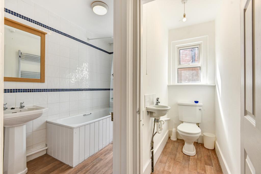 Bright and clean bathroom suite featuring a lar...