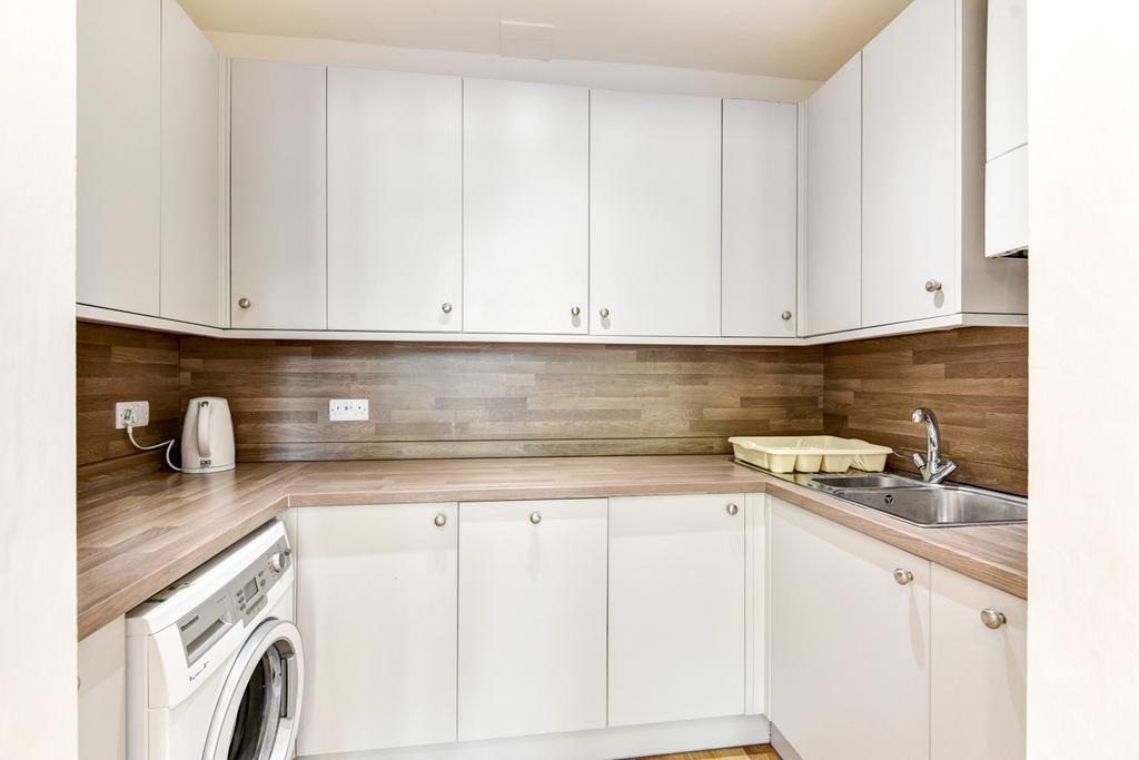 A modern and clean kitchen with ample white cab...