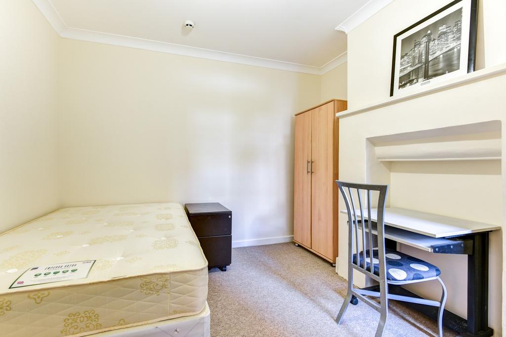 A well-lit double bedroom featuring a comfortab...
