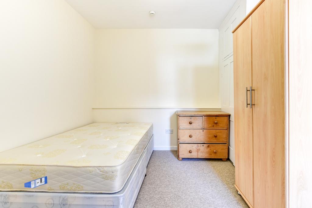 A simple, clean student bedroom featuring a sin...