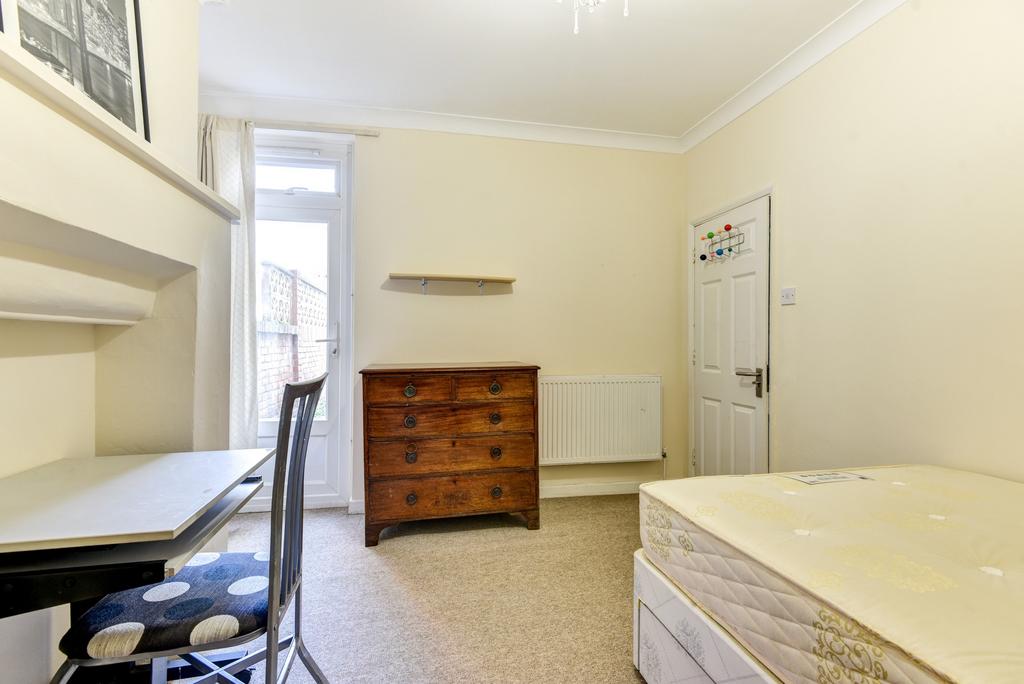 A modest student room featuring a single bed, d...