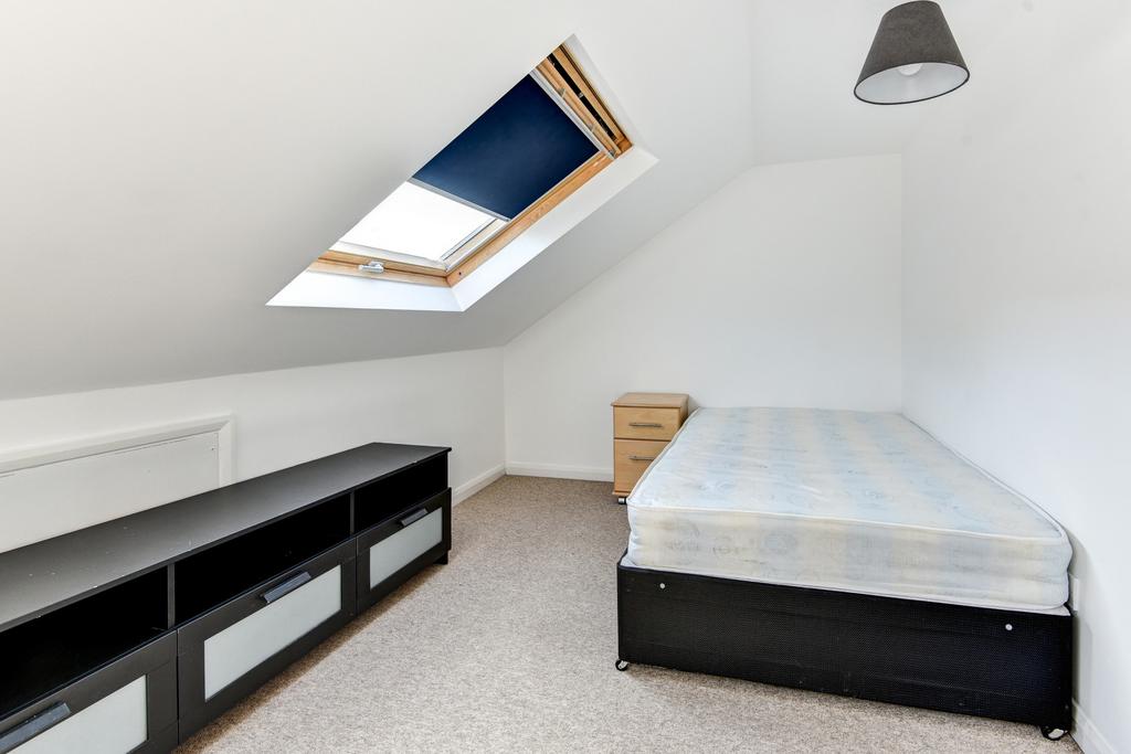 A bright and tidy bedroom featuring a comfortab...