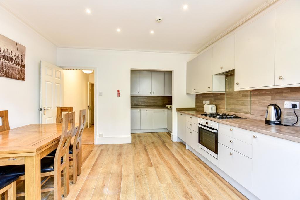 Bright and modern kitchen with white cabinetry,...