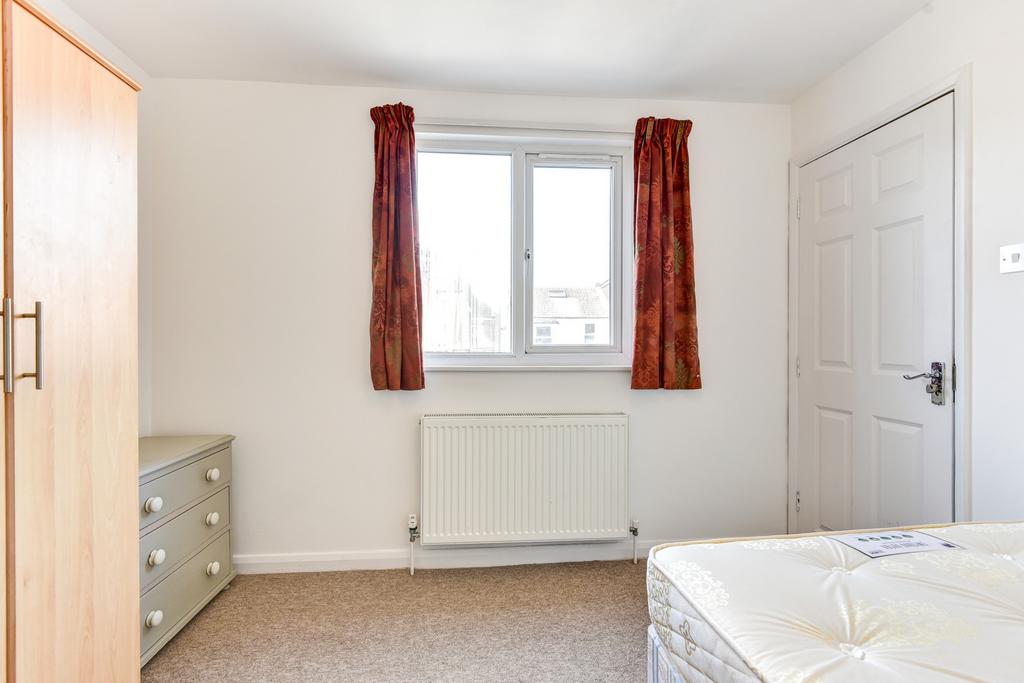 A bright and welcoming master bedroom with a la...