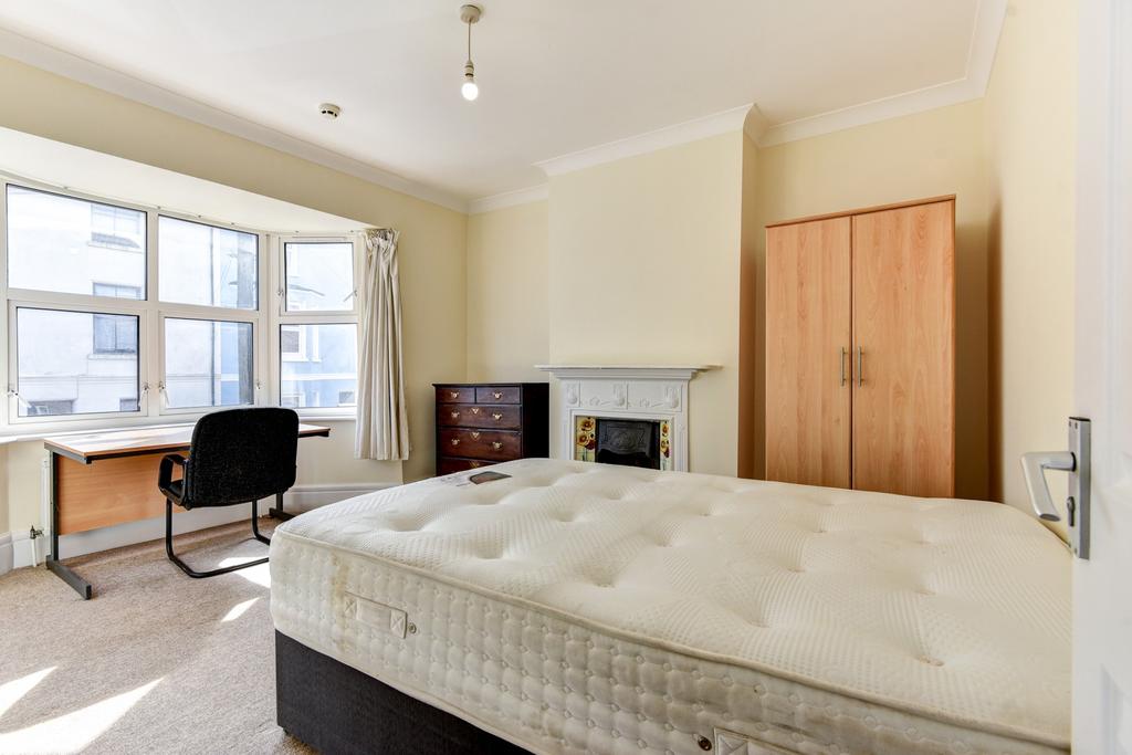 A bright and tidy bedroom featuring a comfortab...