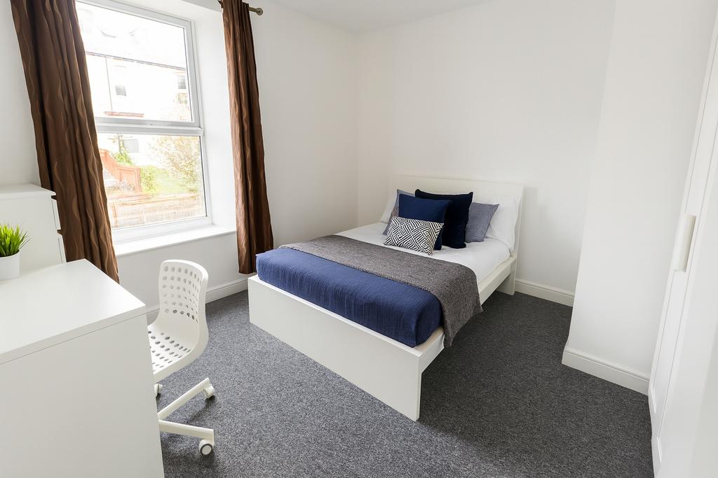 Bright and modern single bedroom featuring a la...