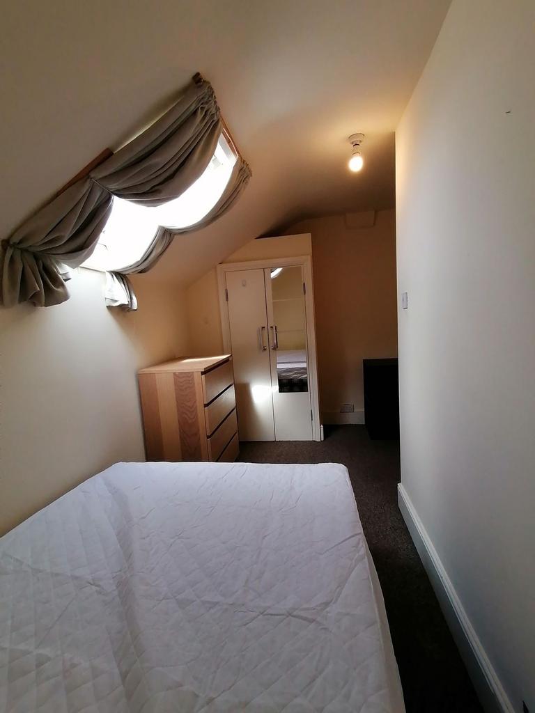 Cozy attic double bedroom with a sloped skyligh...