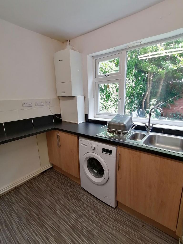 Bright galley-style kitchen with a large window...