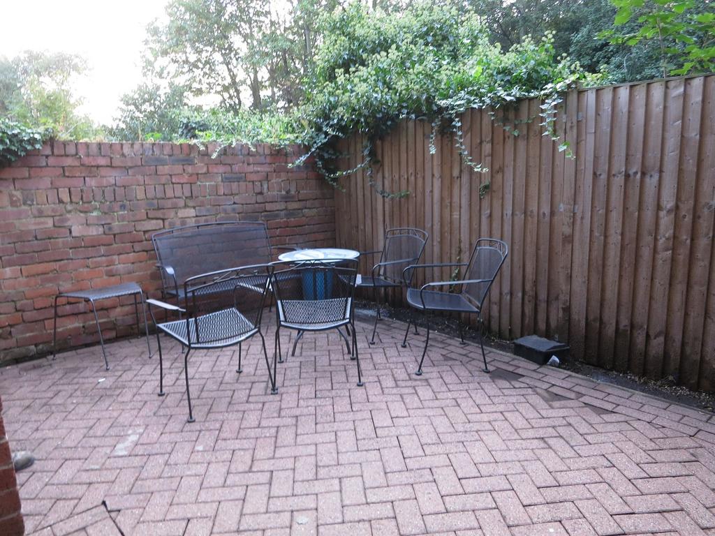 Private paved patio with metal outdoor seating ...
