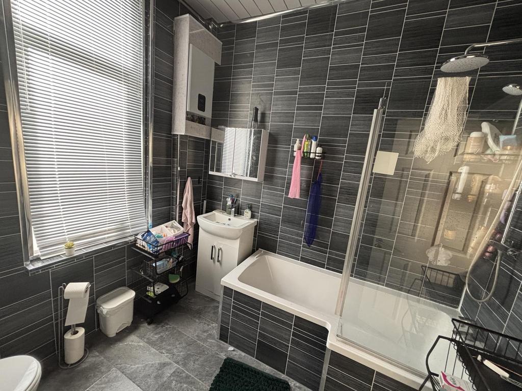Modern bathroom with charcoal tiled walls, a ba...