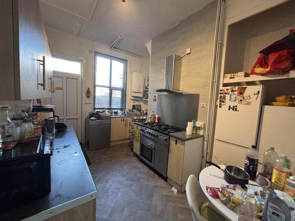 Bright galley kitchen with large window providi...