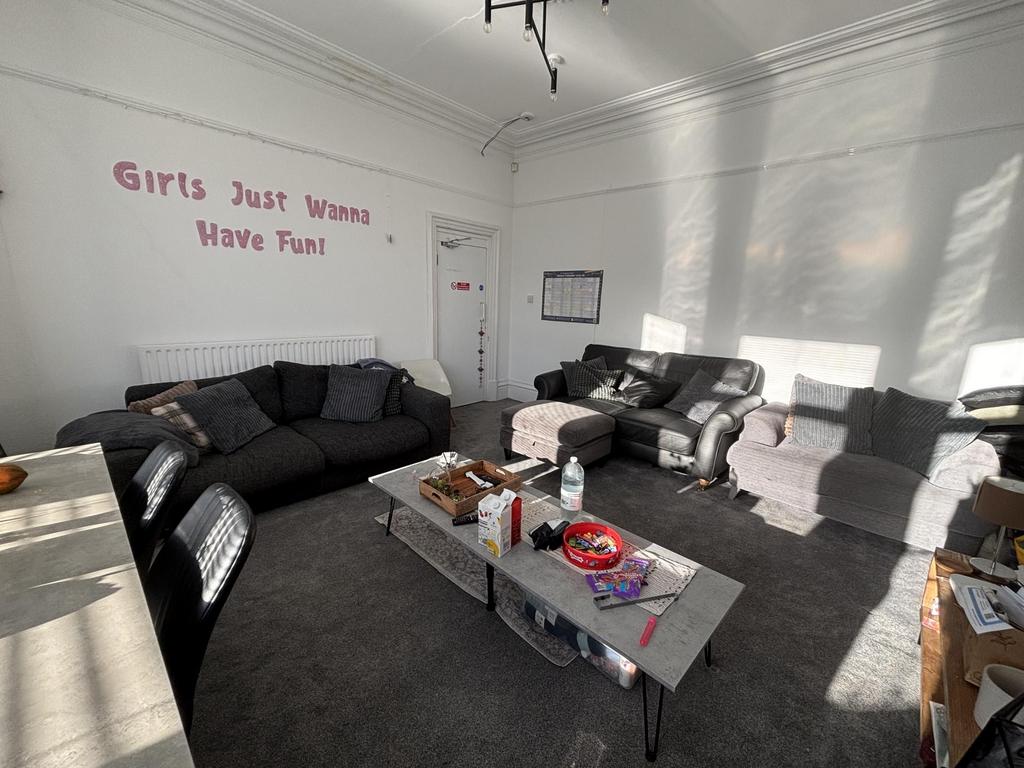 Bright communal lounge with multiple comfortabl...