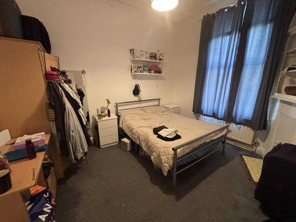 Bright, neatly kept double bedroom with a metal...
