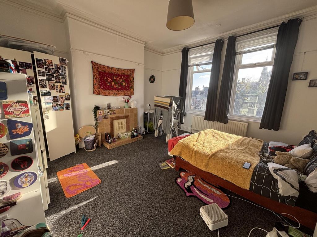 Bright, well-lit bedroom with large windows, ne...