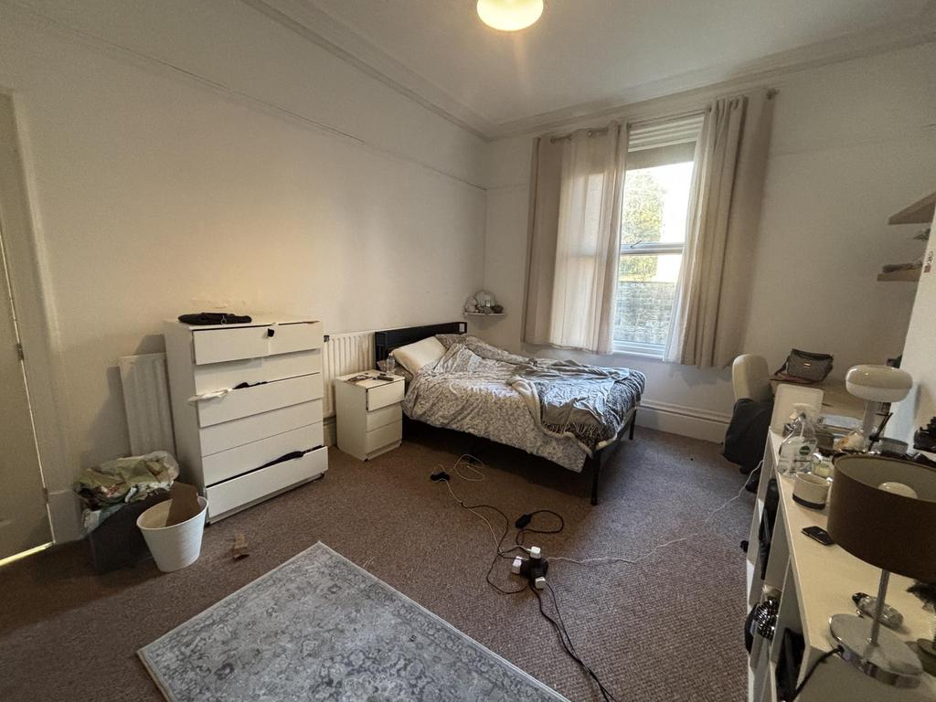 Bright, neatly arranged double bedroom with a c...