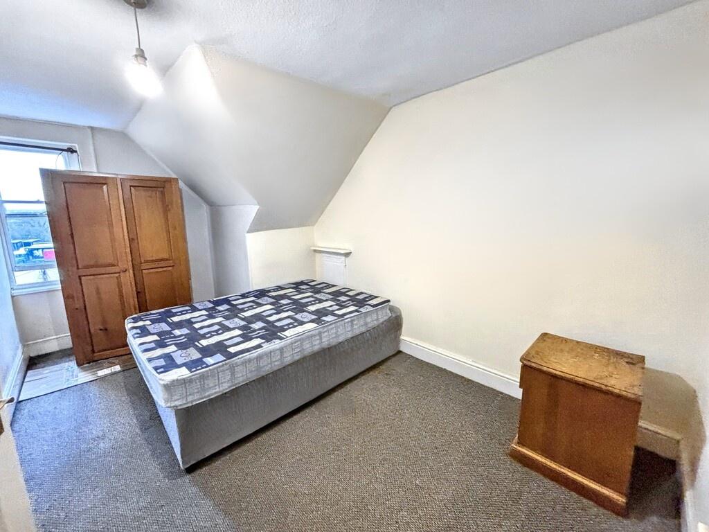 Bright, simply furnished bedroom with a single ...