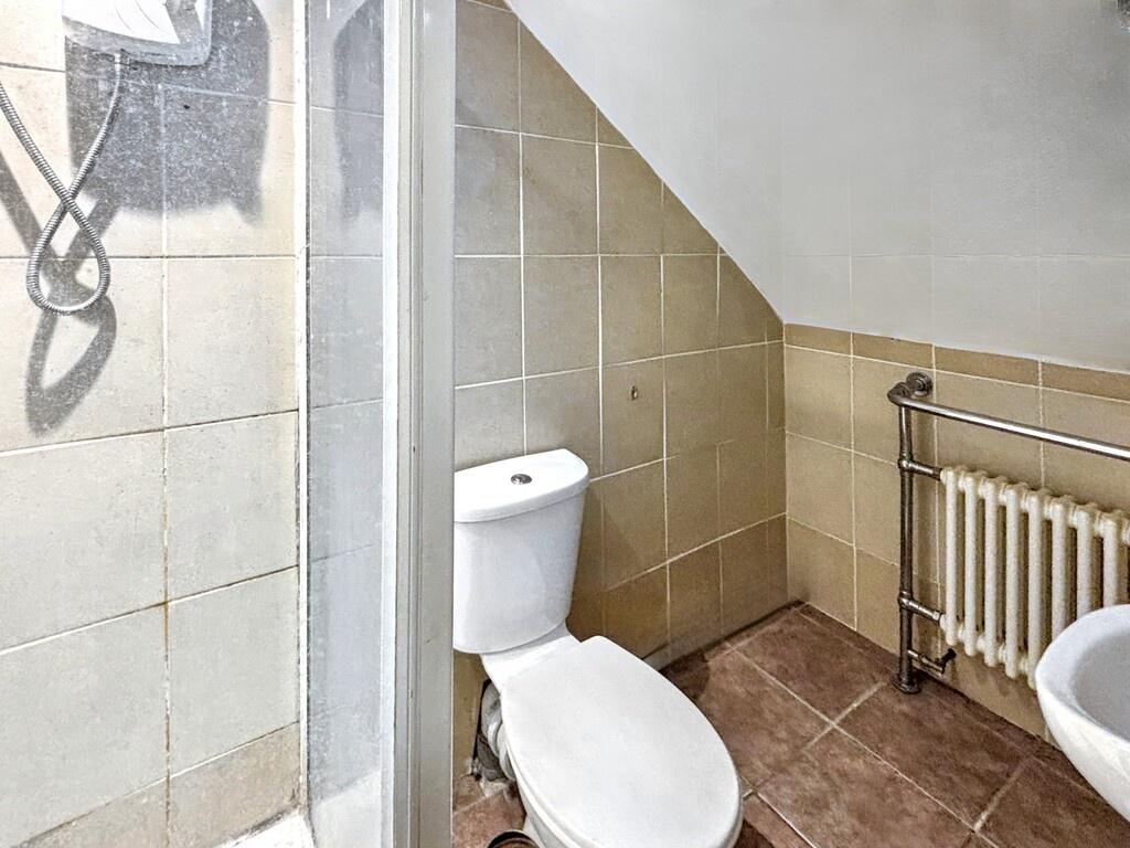 Neat bathroom with a toilet, corner shower and ...