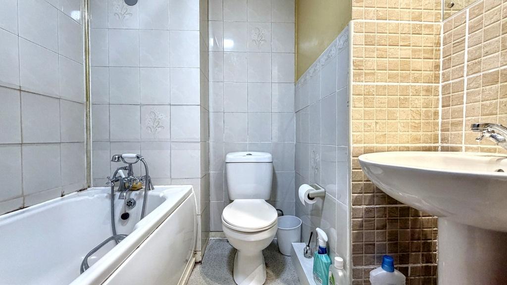 Bright, modern bathroom with a bathtub and wall...