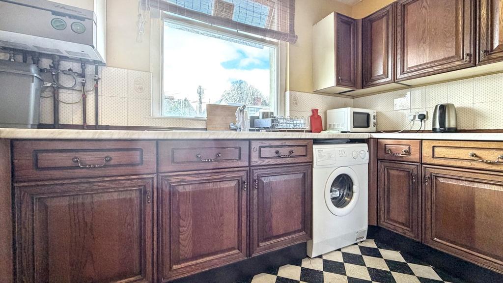 Well-maintained kitchen with classic wooden cab...