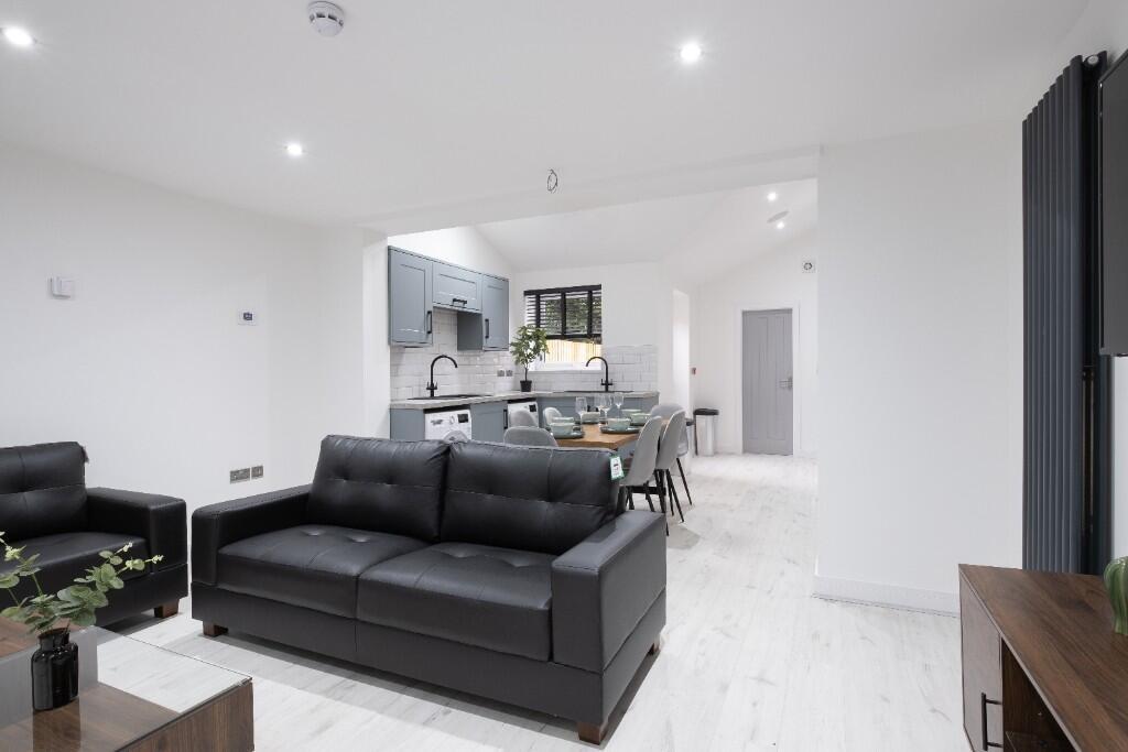 A modern, bright living room with sleek black s...