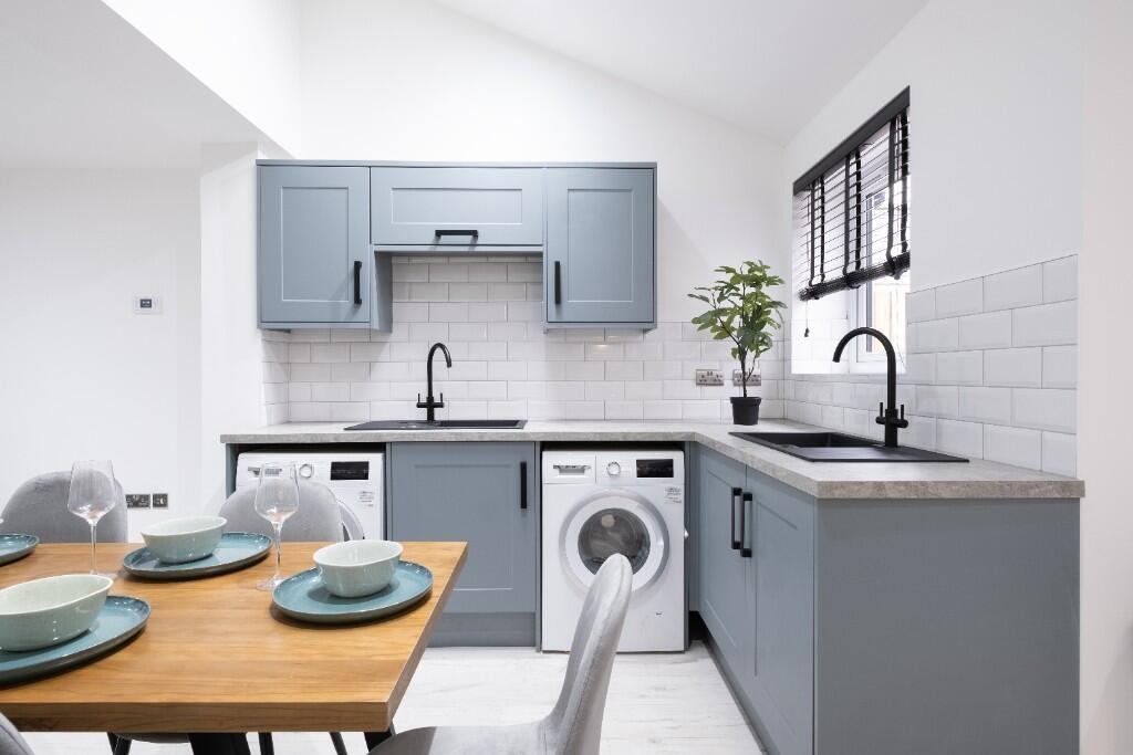 Bright and modern kitchen with stylish blue cab...