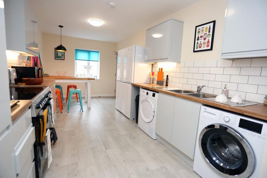 Bright modern kitchen with white cabinets, wood...