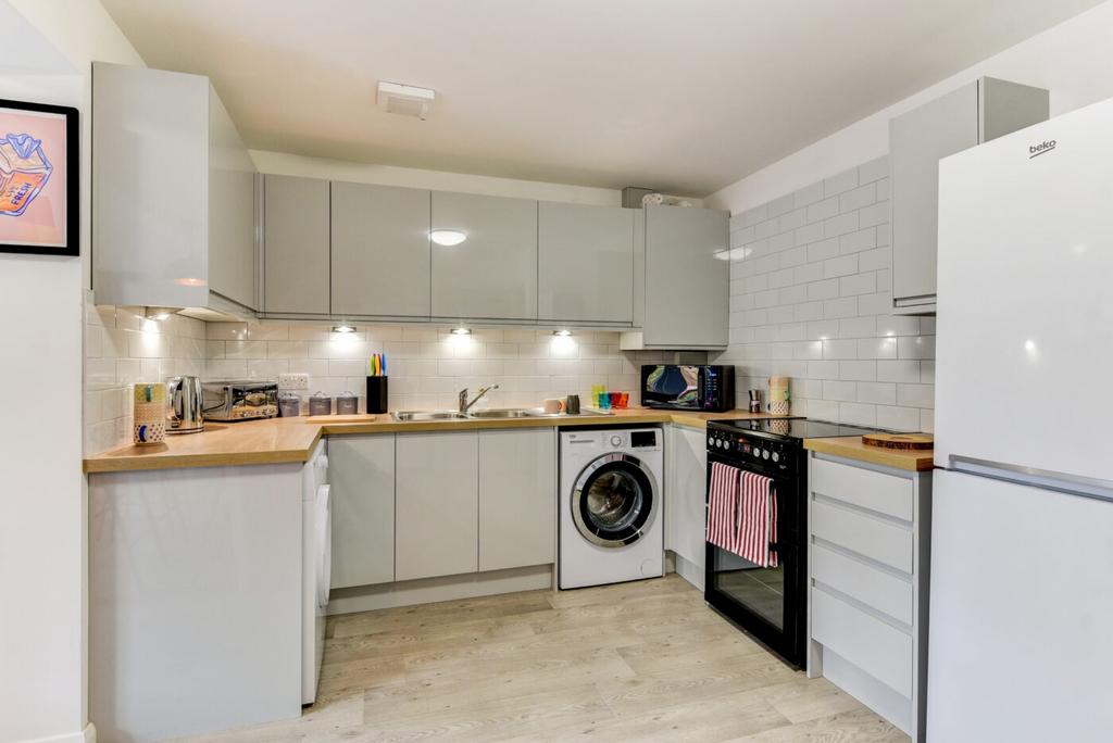 Modern fitted kitchen with glossy grey cabinets...