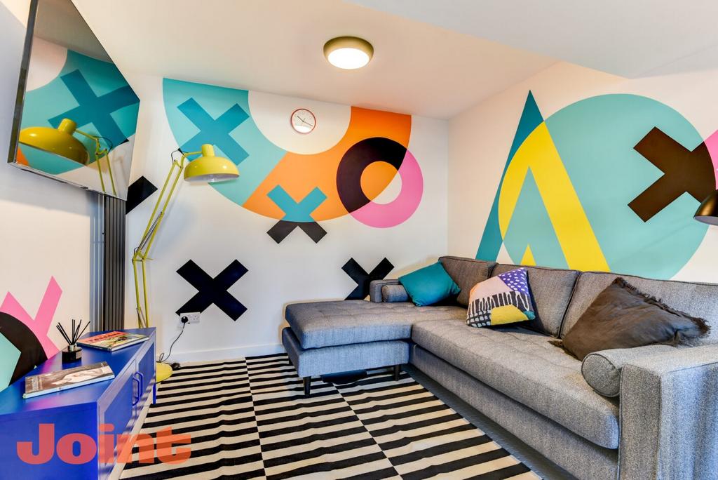 Bright, modern communal lounge with a large gre...