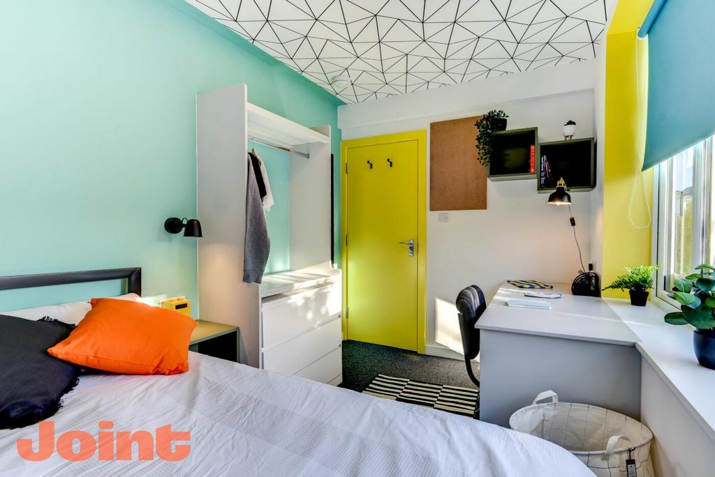 Bright, modern single bedroom featuring a comfo...