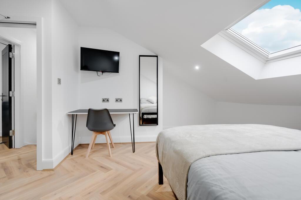 A bright and modern bedroom featuring ample nat...