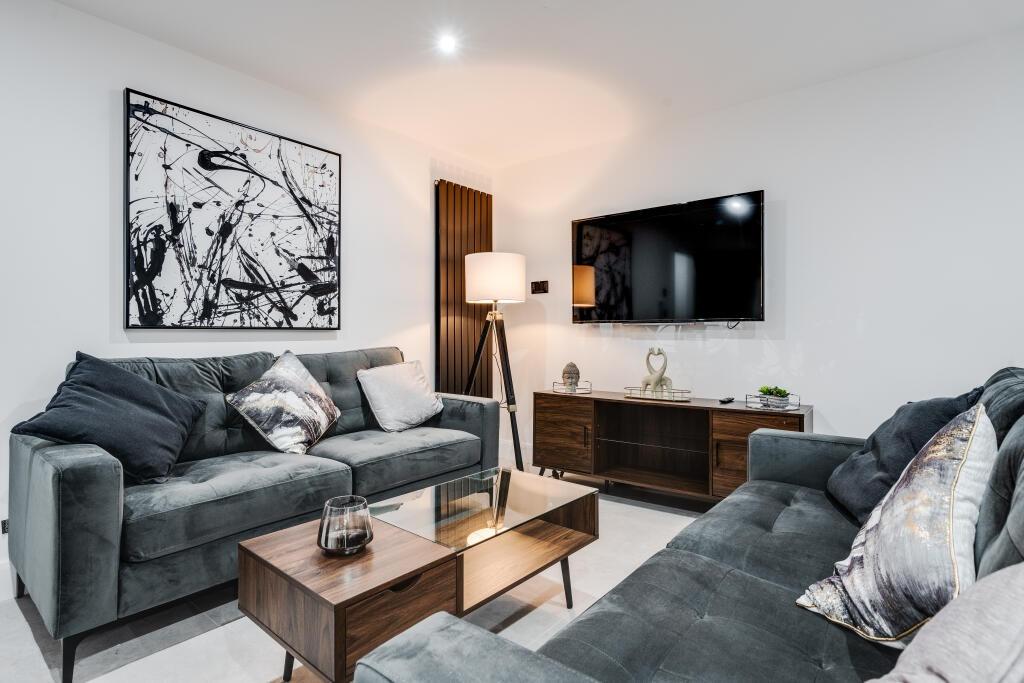 A modern, well-lit living room featuring comfor...