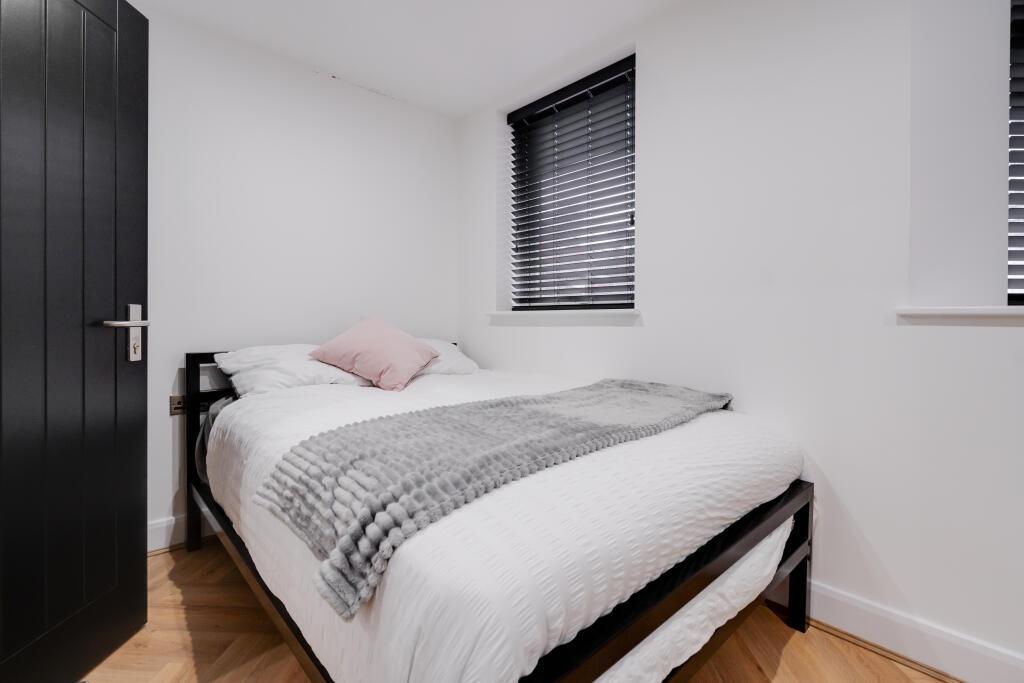 A bright and spacious master bedroom with a com...