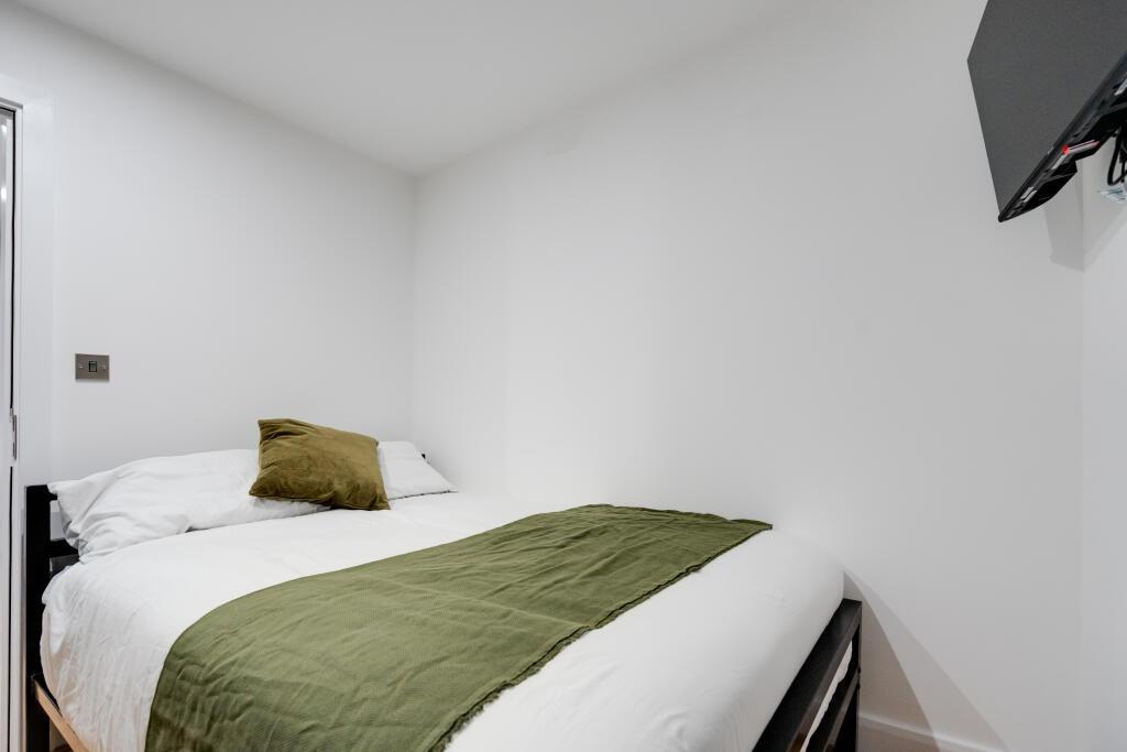 A spacious and bright master bedroom featuring ...