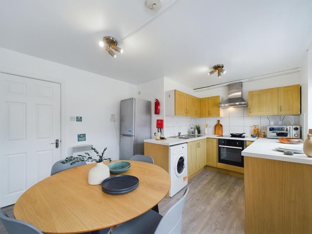 Bright and modern kitchen with ample wooden cab...