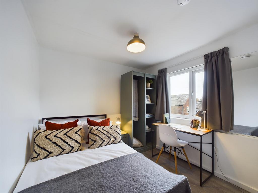 Bright and welcoming bedroom featuring a comfor...