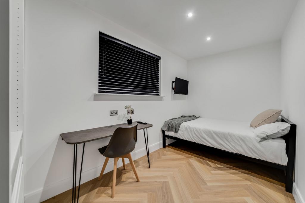 A neatly maintained single bedroom featuring a ...