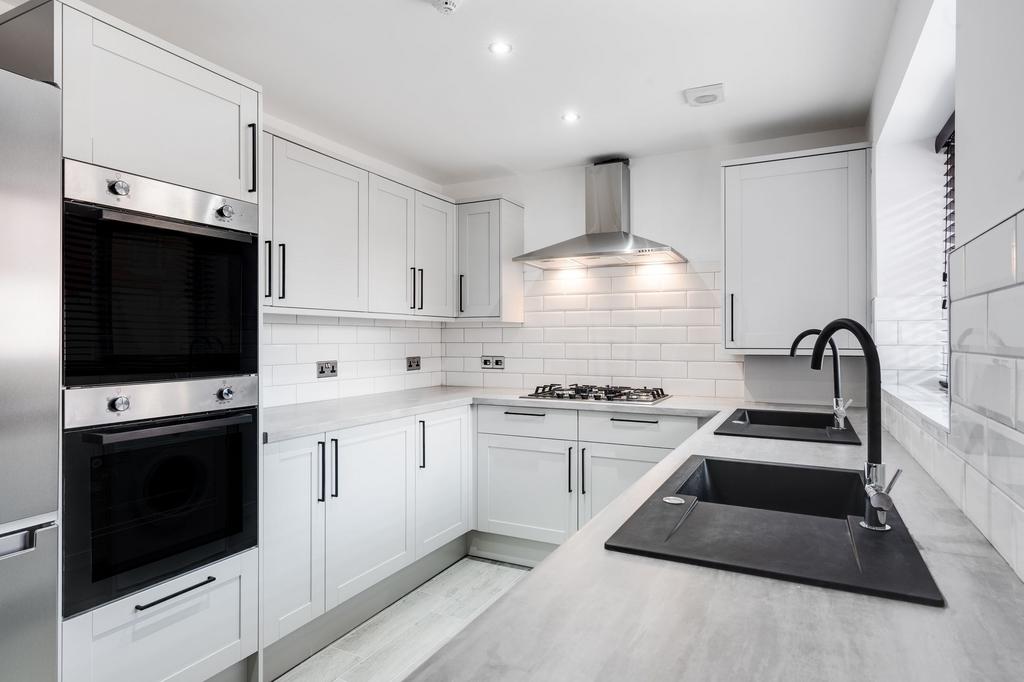 Modern fitted kitchen with white shaker-style c...