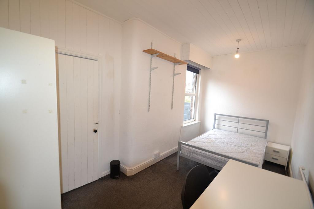 A tidy student bedroom featuring a single bed w...