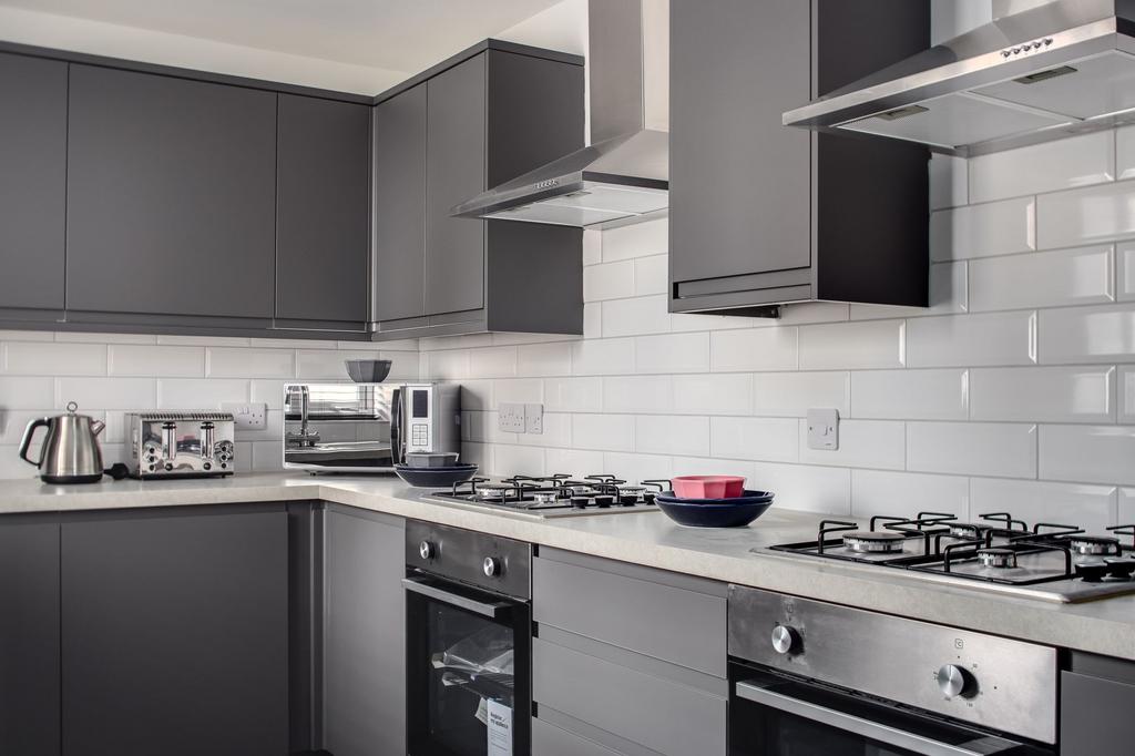 Modern fitted kitchen with dark cabinetry, tile...