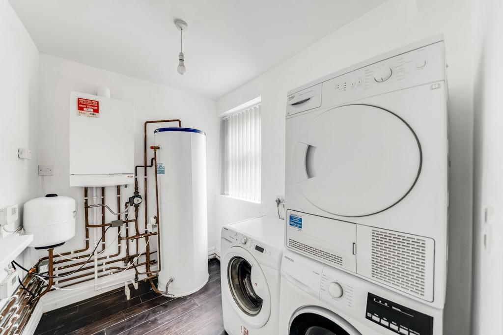 A functional laundry area featuring a washing m...