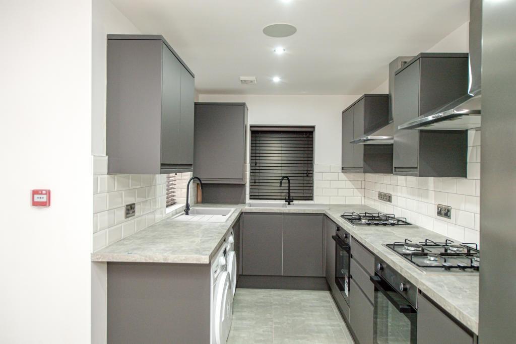 Modern galley kitchen with grey cabinetry, marb...