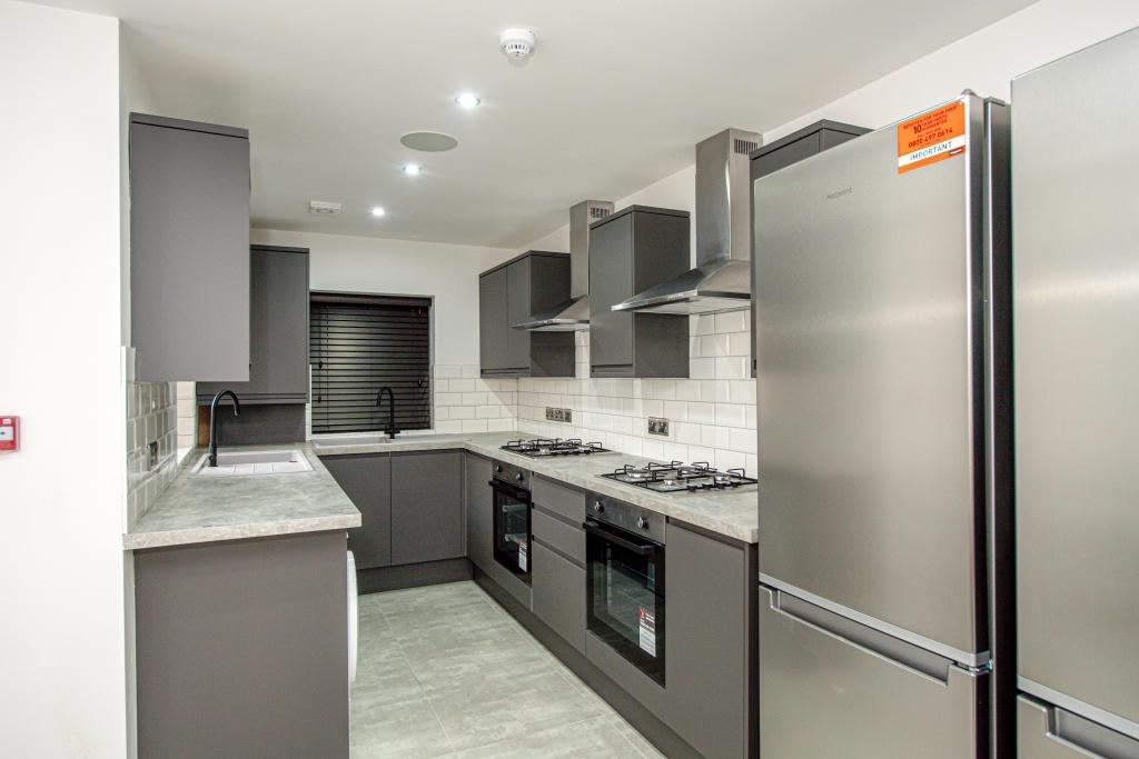 Modern galley kitchen with matching grey cabine...