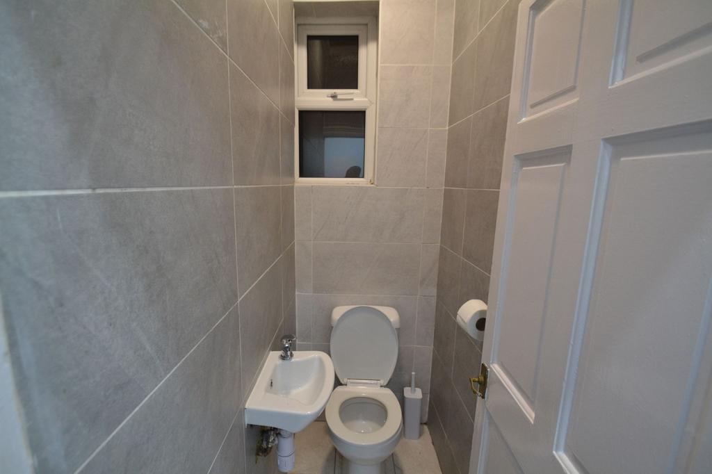 A clean, modern bathroom with neutral grey tile...