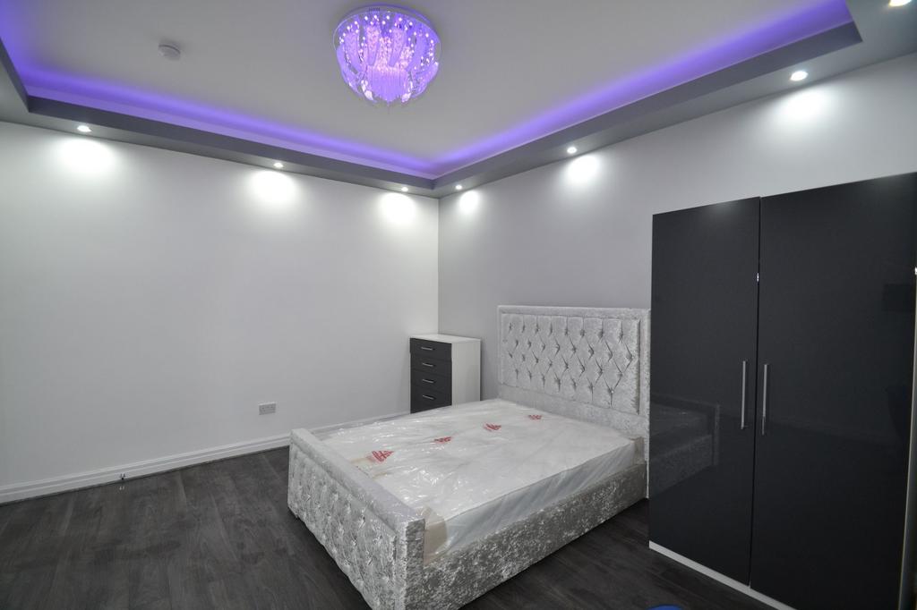 A modern bedroom featuring a plush, tufted head...