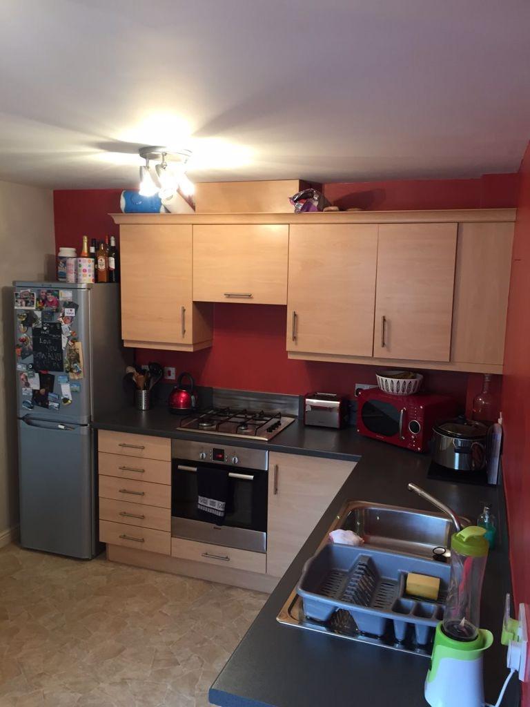 Modern fitted kitchen with light wood cabinetry...