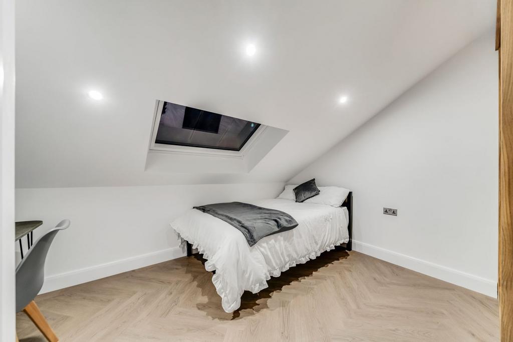 A cozy double bedroom with white bedding and a ...